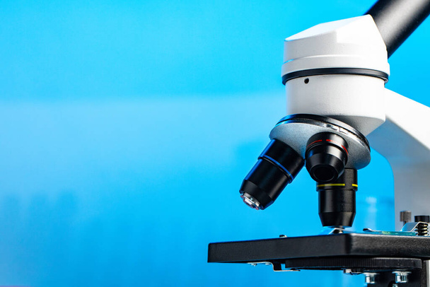 Lab microscope close up against blue background - Foto, imagen