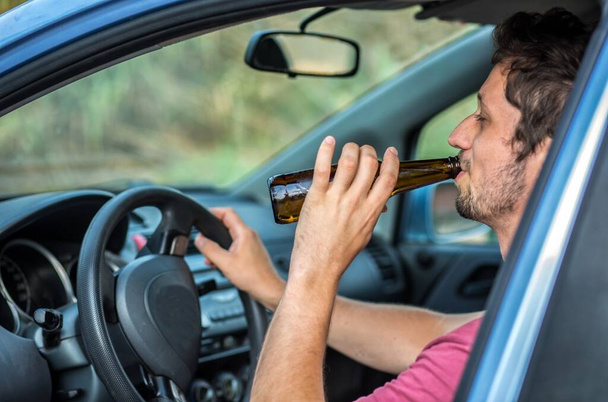 車を運転しながら酒を飲む男 - 写真・画像