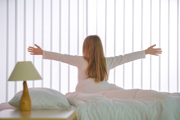The young girl do exercise near the bed - Photo, Image