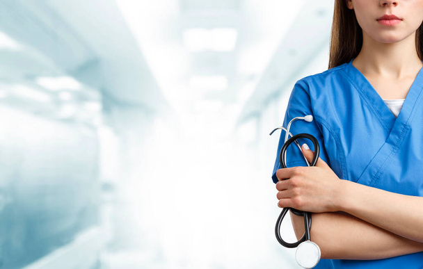 Detalle de un uniforme de enfermera sobre un fondo azul borroso del hospital del pasillo
 - Foto, Imagen