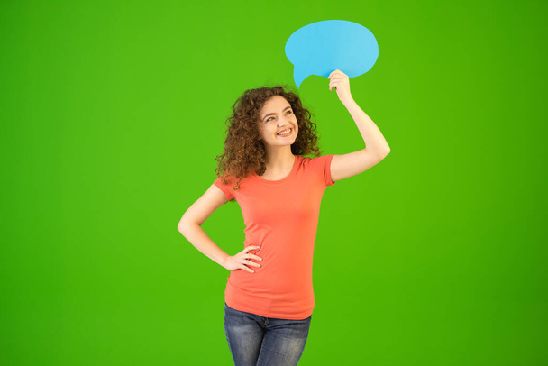 The woman stand with a dialog sign on the green background - Photo, image