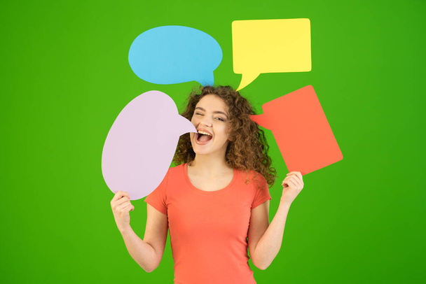 Красивая женщина держит диалоговые знаки на зеленом фоне
 - Фото, изображение