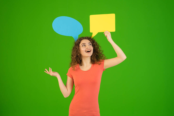 The woman gesture near a dialog signs on the green background - Photo, Image