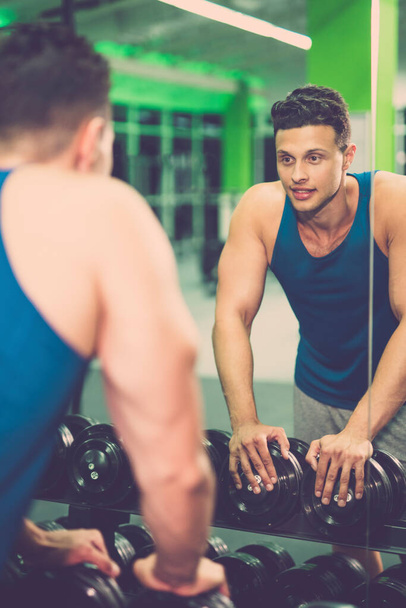 Lo sportivo felice guarda in specchio nel fitness club
 - Foto, immagini