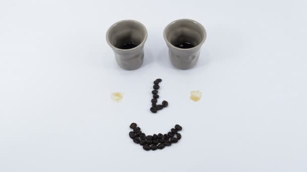 Zurigo, Svizzera - 12 giugno 2020: Mentre due tazze di caffè si riempiono di caffè, le guance si esprimono, i capelli crescono, gli occhi si muovono attraverso l'aggiunta di latte. Movimento di arresto animato
. - Filmati, video