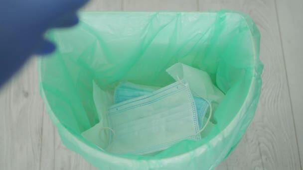 Lääkäri heittää pois roskat Kertakäyttöiset käsineet ja naamio Käytetty ja saastunut päätyttyä sairaalan Service Shift - Materiaali, video