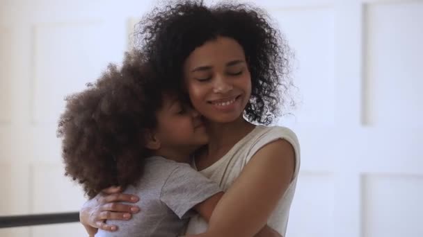 Happy loving black mother hugging cute little child daughter cuddling - Кадры, видео
