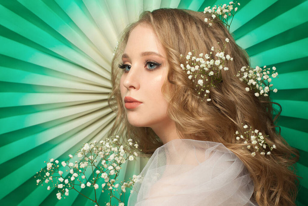 Fiatal modell nő virágos haj zöld háttér - Fotó, kép