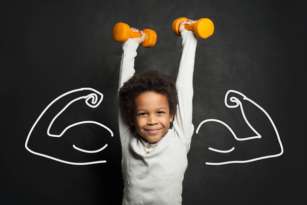 Strong black child boy with dumbbells - Photo, Image