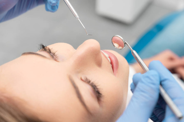 Woman having teeth examined at dentists. Teeth whitening, dental care concept - 写真・画像