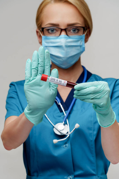 medical doctor nurse woman wearing protective mask and gloves - holding virus blood test tube - Fotoğraf, Görsel