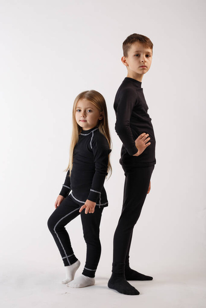 Мальчик и девочка в термальном белье на белом фоне. Спортивная одежда
. - Фото, изображение