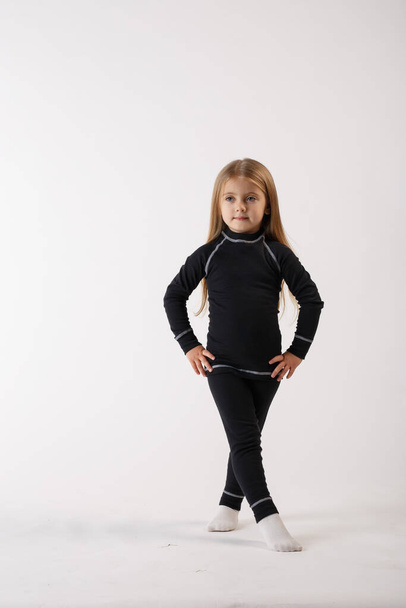 Κοριτσάκι με θερμικά εσώρουχα σε λευκό φόντο. Αθλητικά ενδύματα. - Φωτογραφία, εικόνα