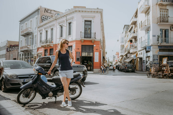 Beautiful girl walking along the street of an old European town, capital of Greece - Athens. Portrait of a tourist girl walking on the street background. - Foto, Imagem