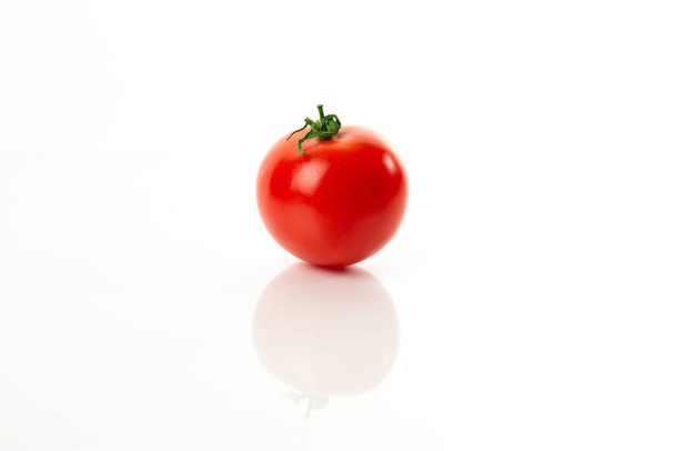 Jeden soczysty świeże czerwone dojrzałe pomidory zbliżenie na białym tle z odbiciem - Zdjęcie, obraz