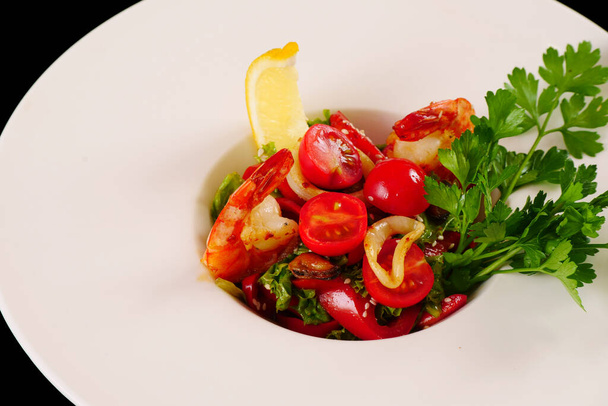 Shrimp, tomato and bell pepper salad with parsley and lemon. Black background - Photo, Image