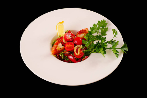 Shrimp, tomato and bell pepper salad with parsley and lemon. Black background - Foto, imagen