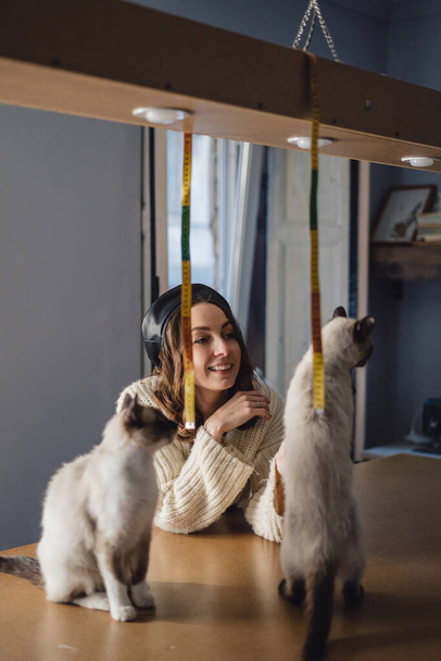 Hübsche Frau spielt mit siamesischen Katzen - Foto, Bild