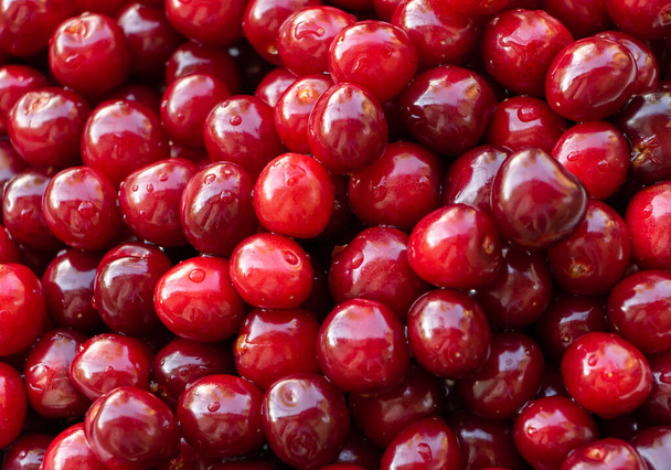 Rode en smakelijke kersen textuur, achtergrond. De voordelen van kersen - Foto, afbeelding