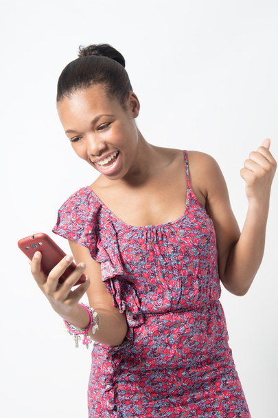 Joven mujer africana emocionada por mensaje de texto
 - Foto, Imagen