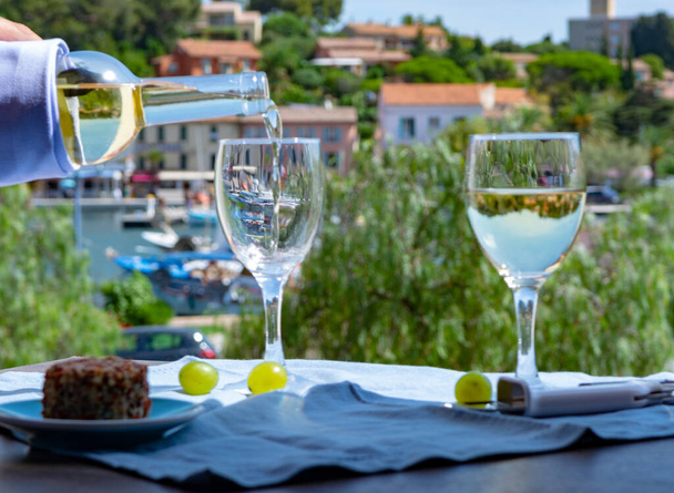 Vino blanco de Provenza, Francia, servido frío con queso de cabra suave en la terraza al aire libre en dos copas de vino en un día soleado
 - Foto, Imagen