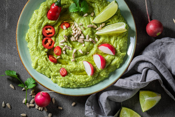 Vegan guacamole served with crackers, coriander and sunflower seeds - Foto, Imagem
