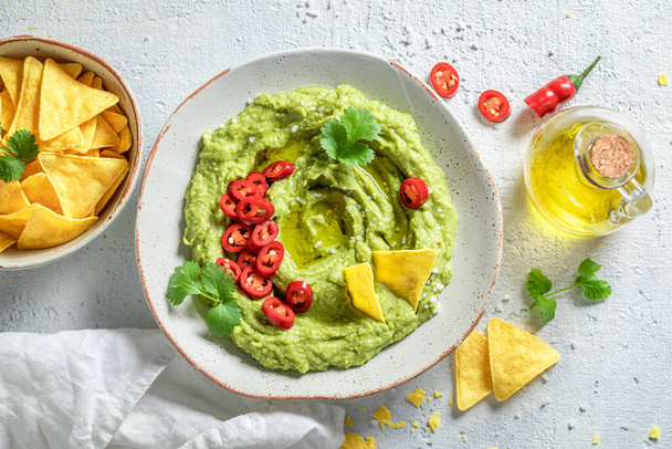 Enjoy your guacamole with tortilla, coriander and chilli peppers - Фото, зображення