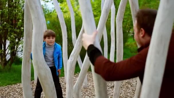 Glücklicher junger Mann und sein kleiner Bruder spielen im Park und verbringen Zeit miteinander - Filmmaterial, Video