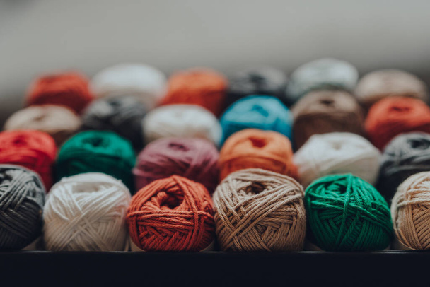 Nahaufnahme einer Schachtel voller 24 verschiedenfarbiger Amigurumi-Baumwollfäden, selektiver Fokus auf die nächste Reihe. - Foto, Bild