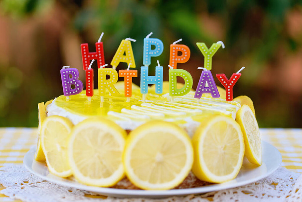 Birthday cake with happy birthday candles. Lemonade birthday party at summer park. food, celebration and festive concept - 写真・画像