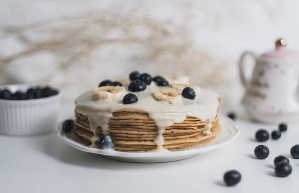 Pancakes with condensed milk with fresh blueberries and banana. - Foto, imagen