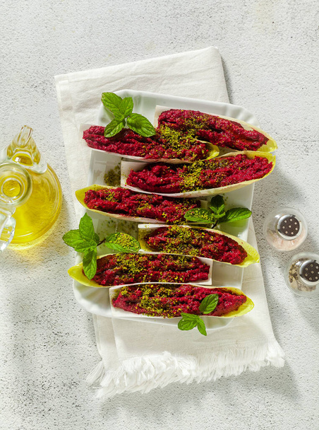 dip of boiled beets and pistachios in leaves of Belgian Endive with mint. healthy summer snack - Фото, зображення