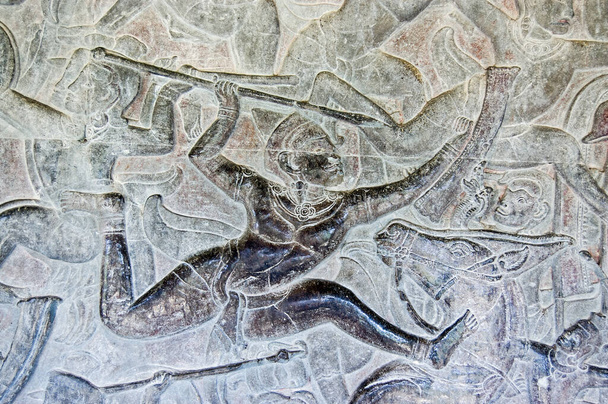 Ancienne sculpture en bas-relief d'un soldat lançant une lance pendant la bataille. Mur intérieur du temple Angkor Wat, Siem Reap, Cambodge. - Photo, image