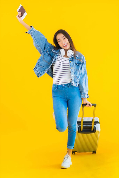 Portrait beautiful young asian woman travel and leisure with luggage bag and passport , boarding pass on yellow isolated background - Fotografie, Obrázek