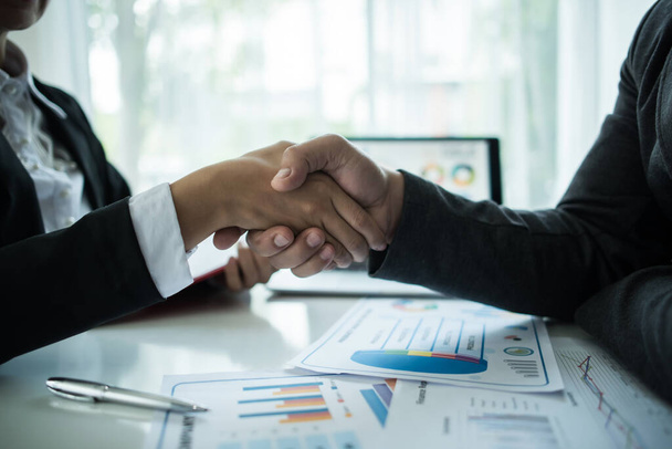  zakenman schudden handen om een deal met zijn partner te verzegelen - Foto, afbeelding