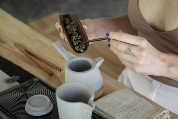 Ceremonia del té chino experiencia. Exquisito té caliente en la tradicional ceremonia del té chino. Mujer caucásica participando en una clase tradicional de ceremonia del té
.  - Foto, imagen