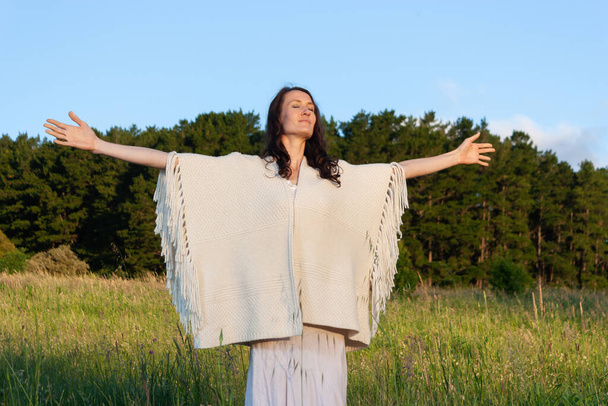 Mujer joven con los brazos levantados disfrutando de la naturaleza
 - Foto, imagen