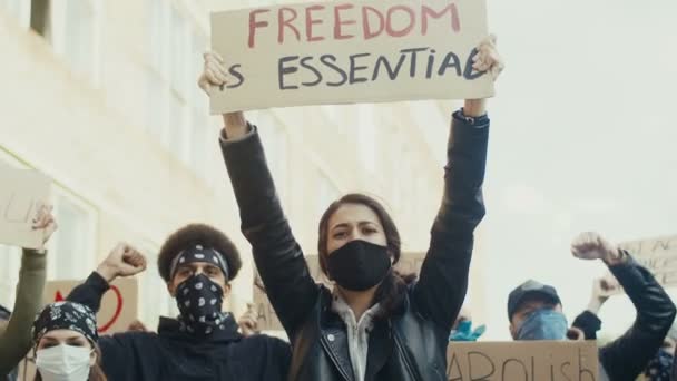Mooie blanke jonge vrouw in masker met poster Vrijheid is essentieel onder mensen die protesteren tegen racisme en voor de mensenrechten. Manifestatie voor gelijkheid. - Video