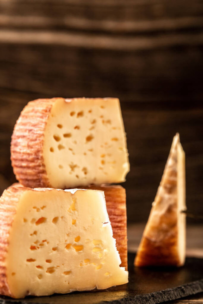 ručně vyráběný sýr podávaný na dřevěném stole, tradiční kousky francouzského a italského sýra. mezera pro text. - Fotografie, Obrázek