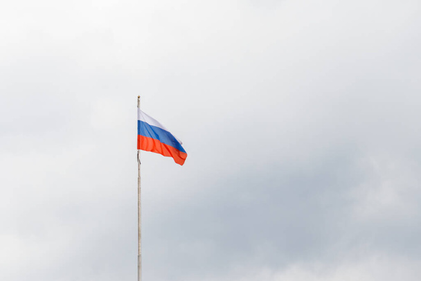 Acenando bandeira da Rússia contra o céu nublado sombrio - Foto, Imagem