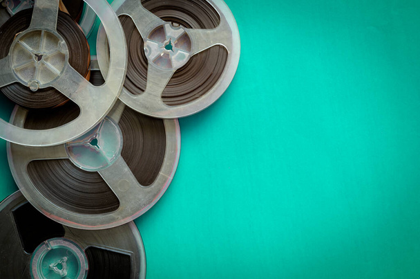 Reels with a magnetic tape on turquoise. Random bobbins with audio recordings. Nostalgia, pleasant memories. Copy space. Flat lay. - Photo, Image