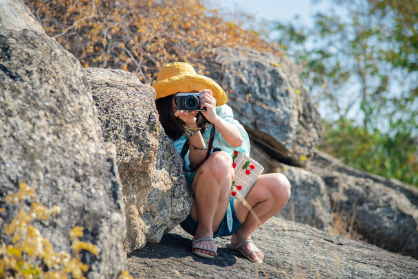 Asiático linda mujer pantalones vaqueros cortos con sombrero de senderismo y cámara en el bosque en la montaña con acantilado con emoción feliz y la libertad en el concepto de viajes, estilo de vida activo, vacaciones, superar los obstáculos en la vida
 - Foto, imagen