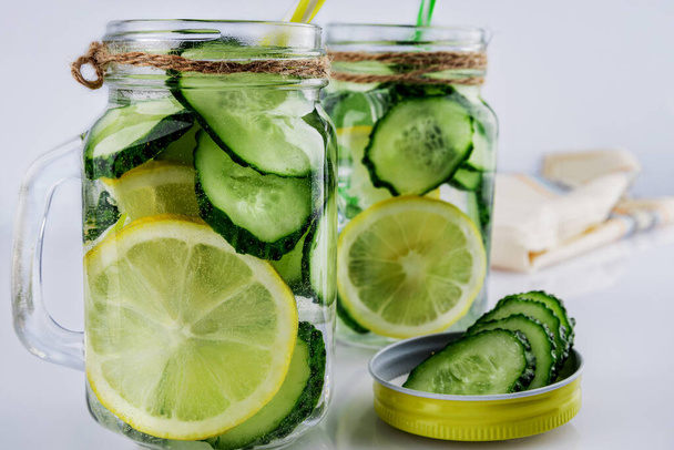 Cold drink, two retro glass cup of lemonade with cucumber and lemon on a white background, shallow depth of field, selective focus. Health drink concept. - Photo, Image