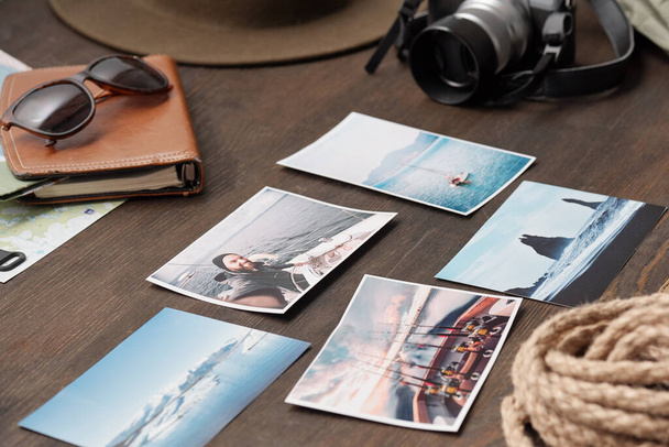 Close-up de belas fotos cênicas de viagens colocadas em mesa de madeira com coisas caminhadas
 - Foto, Imagem