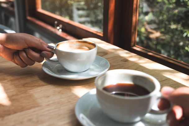 Imagen de cerca de dos personas sosteniendo y bebiendo café por la mañana
 - Foto, imagen