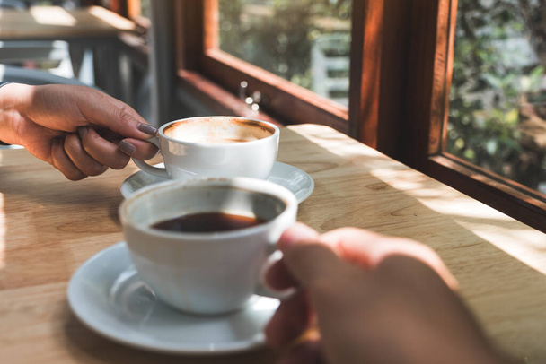 Closeup image of two people holding and drinking coffee in the morning - Photo, Image