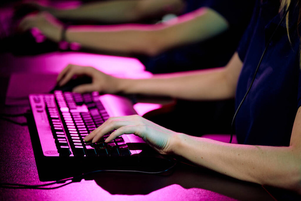 Hands of young female operator of call center touching keys of computer keyboard while consulting one of clients or playing video game - Foto, Bild