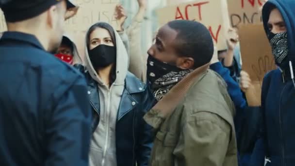 Ein junger afroamerikanischer Demonstrant schreit Polizisten bei einer Demonstration für Menschenrechte an. US-Demonstranten prügeln sich bei Protest gegen Polizeigewalt mit Polizisten. - Filmmaterial, Video