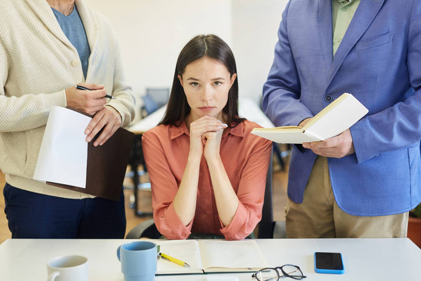 Розгнівана молода кавказька жінка, що сидить за офісним столом, відчуває стрес на роботі, невпізнаний колега і шеф дратує її. - Фото, зображення