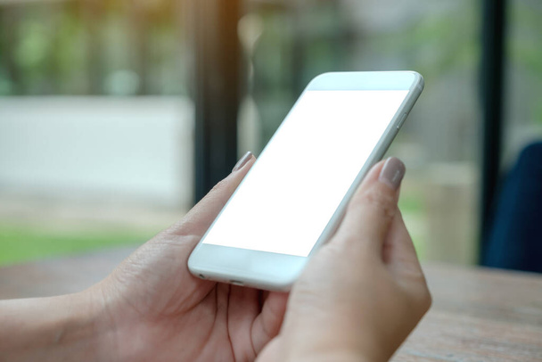 Obrázek ženy držící bílý chytrý telefon s prázdnou plochu obrazovky se zeleným přírodním pozadím - Fotografie, Obrázek